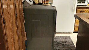 A kitchen with a refrigerator, wooden cabinets, and a tiled floor. - At Paradise in the Valley (Palmer)