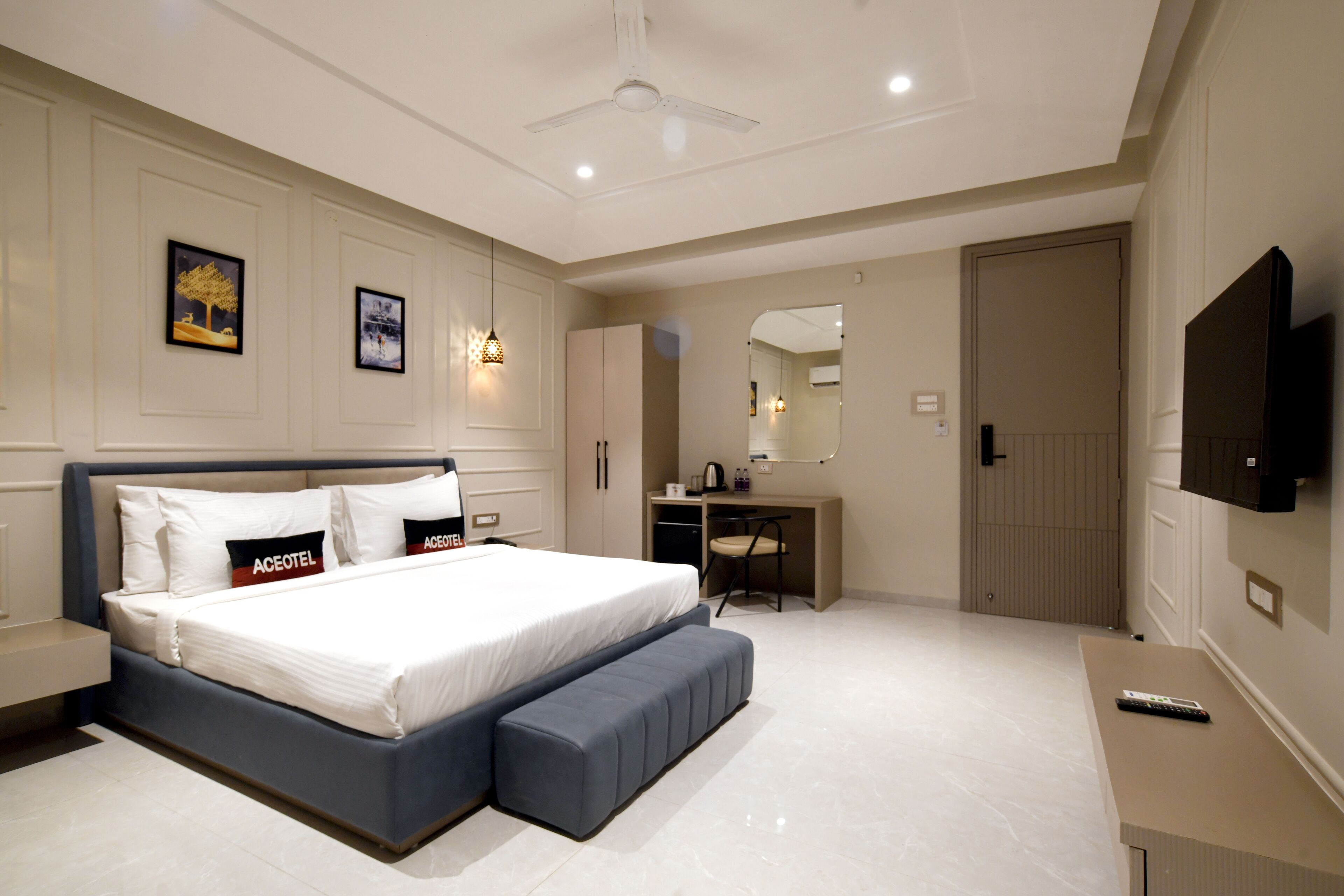 Een moderne hotelkamer met een groot bed, een bureau en een televisie.