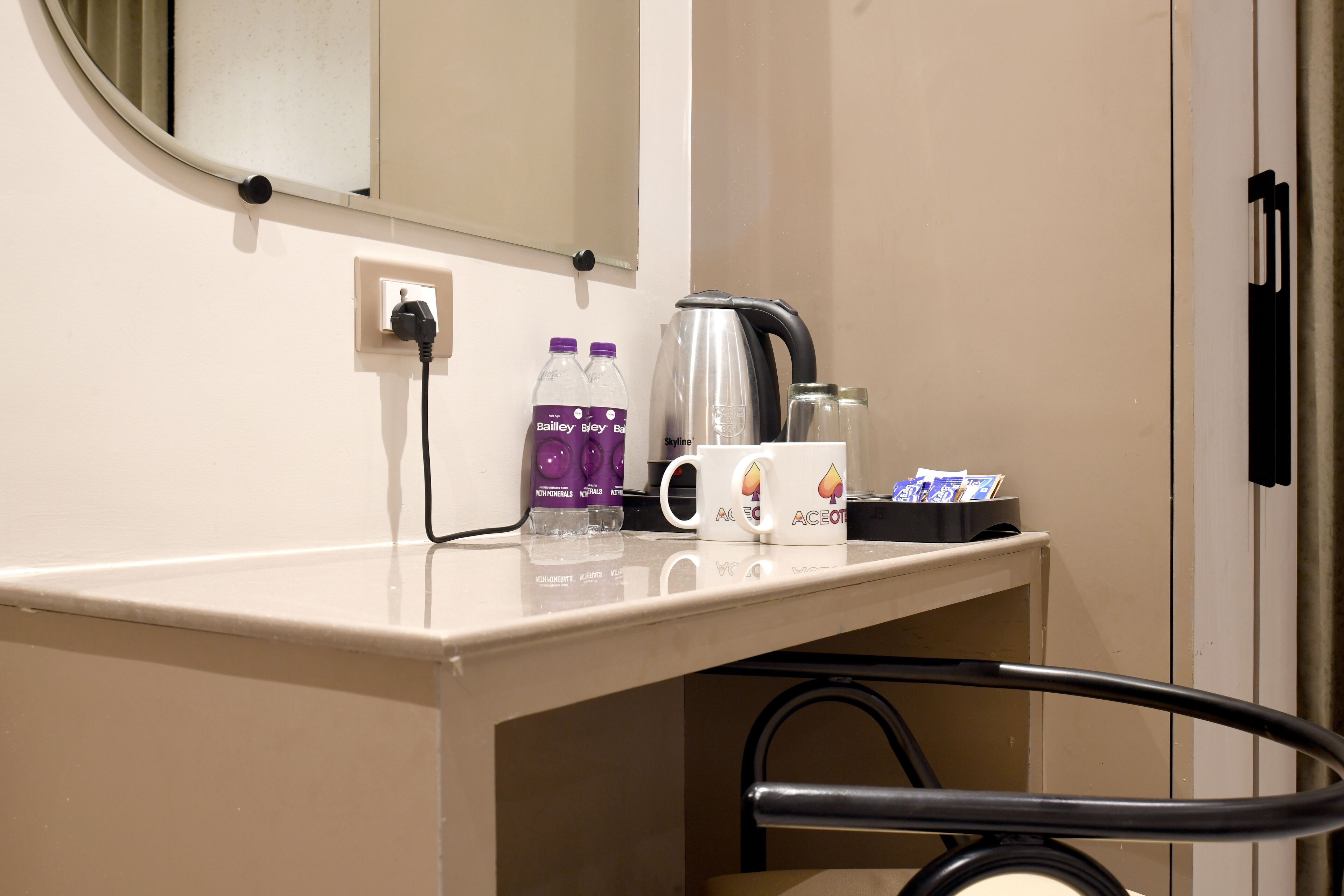 Une chambre d’hôtel équipée d’un mini-bar, d’une bouilloire et de bouteilles d’eau.
