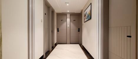 A hallway with a marble floor, two doors, and a sign indicating the floor level.