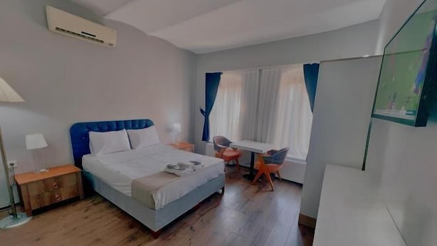 Un dormitorio con una cama, un escritorio, una silla y un televisor.