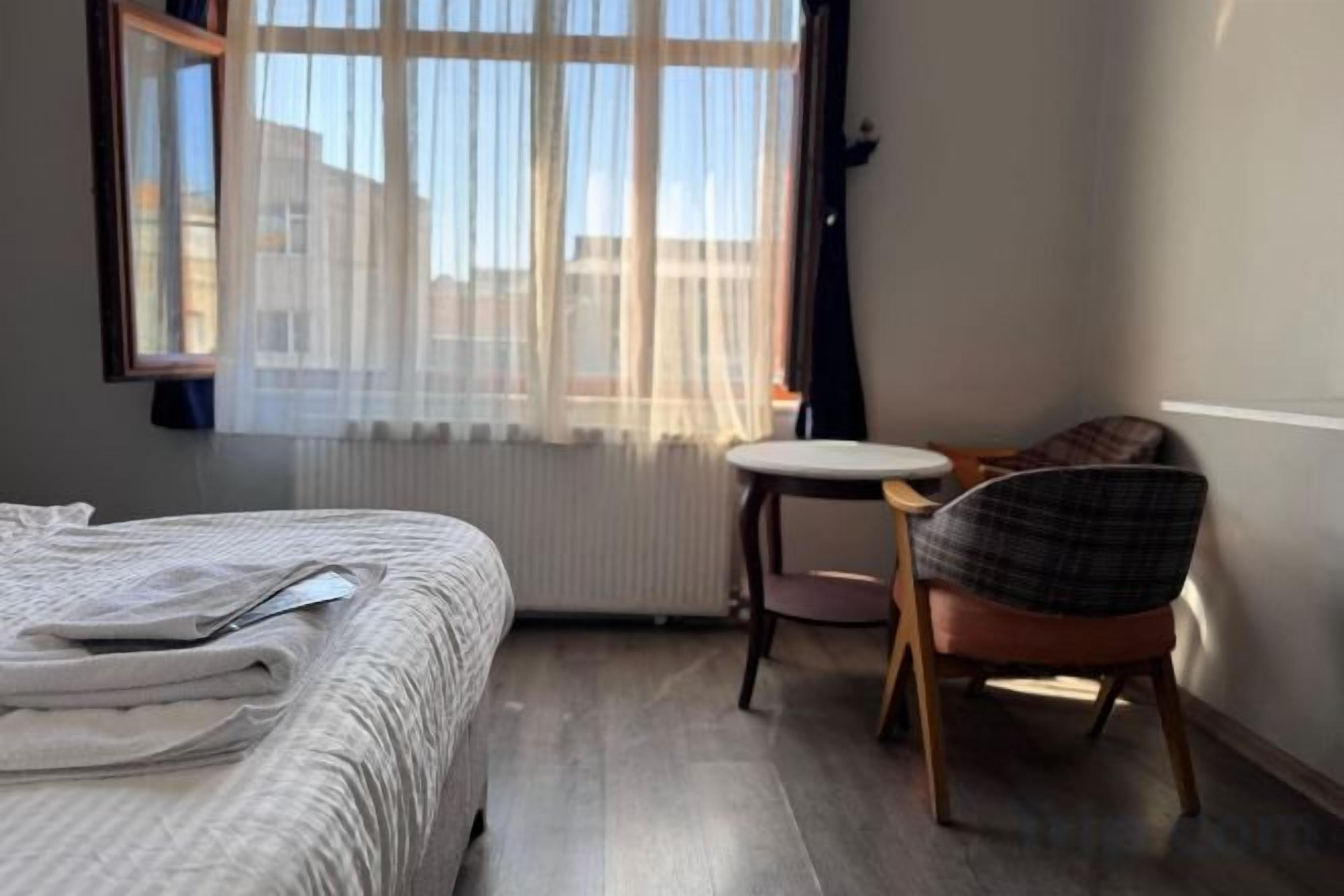 Et hotelværelse med en seng, et lille rundt bord og en stol.