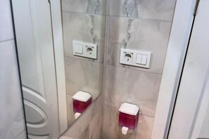 A bathroom with two toilets, each with a mirror above and a flush handle on the wall. - Taksim Centre Geneva Hotel (Istanbul)
