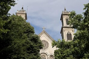 A church with a prominent clock tower and a cross on top, surrounded by trees. - Taksim Centre Geneva Hotel (Istanbul)
