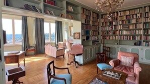 Eine Bibliothek mit Bücherregalen, einem Chandelier und Sitzbereichen.