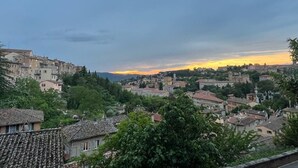 Blick auf eine Stadt mit historischen Gebäuden und einer Hügelkulisse im Hintergrund.