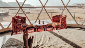 A tent with a bed, two chairs, and a small table. - Miral Night Camp (Wadi Rum)