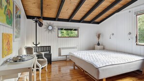 A bedroom with a wooden ceiling, a bed, a desk with a chair, a window, and wall art. - 3 bedroom awesome home in Gilleleje (Gilleleje)