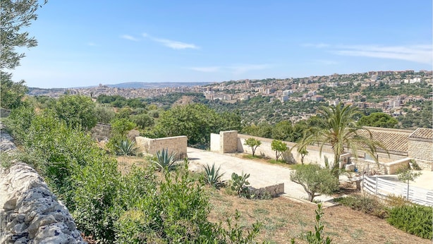 A view of a cityscape from a hilltop with stone walls and sparse vegetation. - 2 bedroom beautiful home in Modica (Modica)