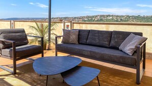 A balcony with a sofa, two chairs, and a small table. - 2 bedroom beautiful home in Modica (Modica)