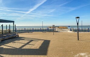 A paved promenade with benches and a viewing area overlooking the sea.
