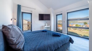 Une chambre moderne avec un grand lit, un téléviseur à écran plat et une vue sur la campagne.