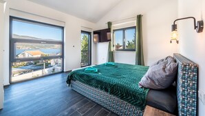 Une chambre avec un grand lit, une vue sur la mer et un balcon.