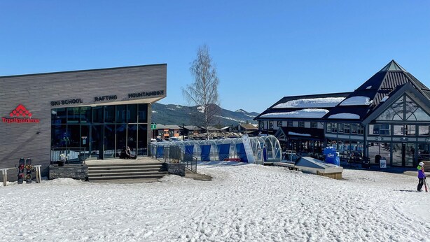 Ein Skischulgebäude mit Glasfassade und Bergblick.