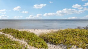 Une plage avec un ciel dégagé et une mer calme.