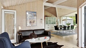 Un salon moderne avec un canapé en cuir noir, une table basse blanche et un meuble vitré.