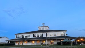 A large two-story building with a covered porch and a weather vane on the roof. - Golf Getaway, 5 miles to Pinehurst (Carthage)