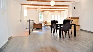 A spacious dining area with a wooden table and chairs, a sofa, and a fireplace. - Beautiful home in Laudun-L'Ardoise with WiFi (Laudun-L'Ardoise)