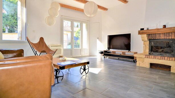 A spacious living room with a wooden ceiling, a fireplace, a large TV, and a dining table with chairs. - Beautiful home in Laudun-L'Ardoise with WiFi (Laudun-L'Ardoise)