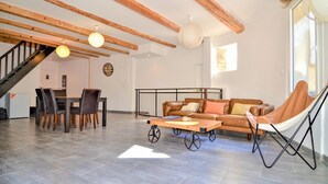 A spacious living area with a high ceiling, exposed wooden beams, a dining table with chairs, a sofa, and a hammock. - Beautiful home in Laudun-L'Ardoise with WiFi (Laudun-L'Ardoise)