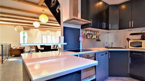 A modern kitchen with a central island, dark cabinets, and a microwave. - Beautiful home in Laudun-L'Ardoise with WiFi (Laudun-L'Ardoise)