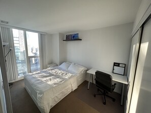 Enjoy a clean and functional space with a comfortable bed, desk, and city view.