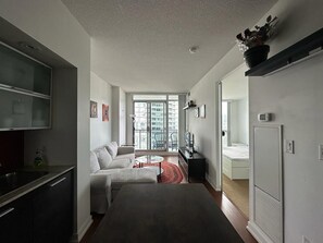 Relax in a spacious room with a large bed, sofa, and city views.