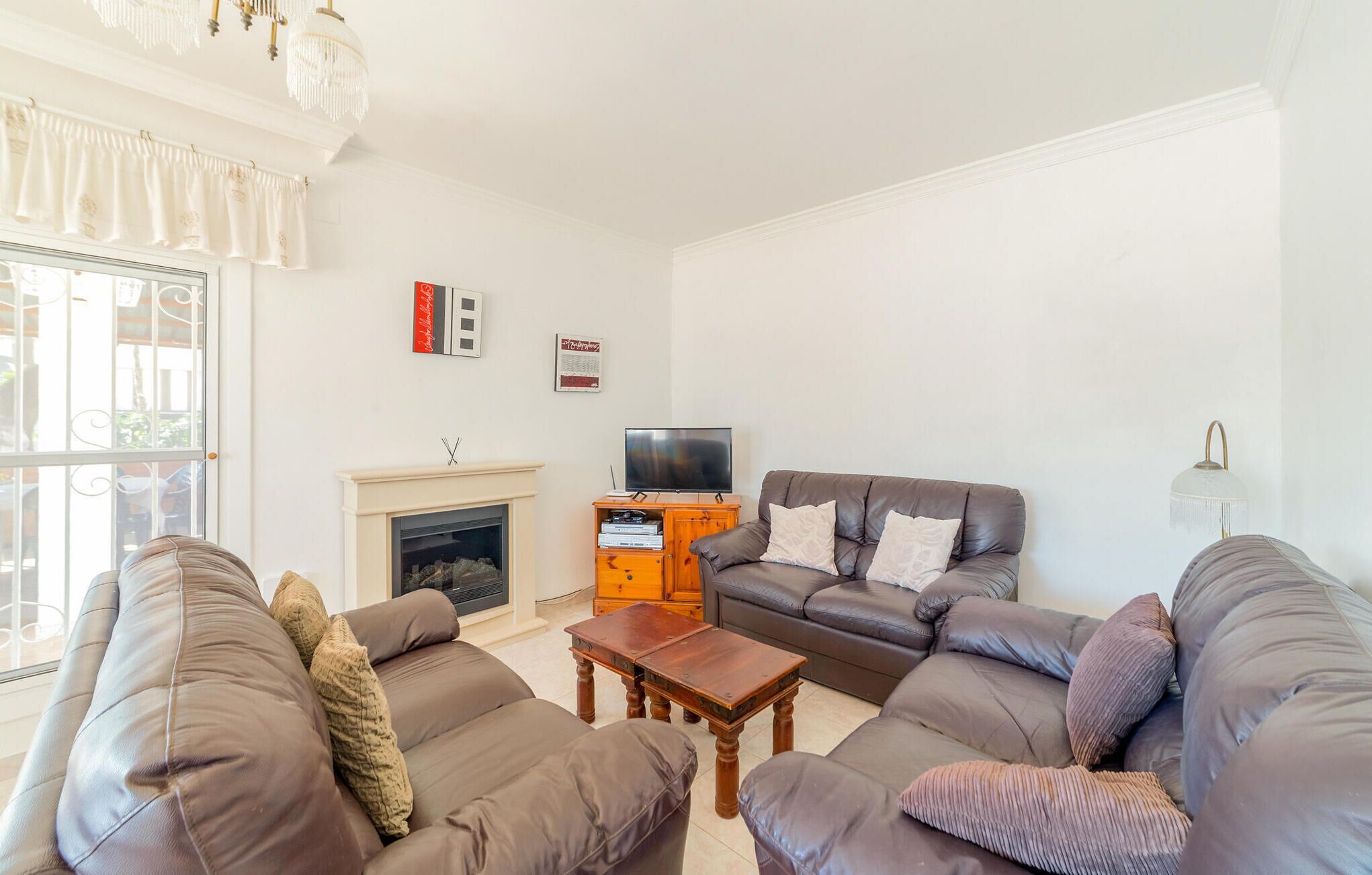 Una sala de estar con chimenea, televisor y dos sofás.