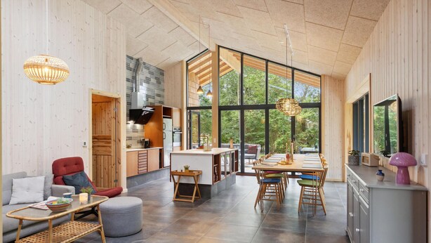 A spacious living area with a dining table, a kitchen with large windows, and a cozy seating area. - Gorgeous home in Højby with sauna (Højby)