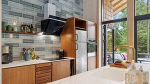 A modern kitchen with a large window, a built-in oven, and a stainless steel refrigerator. - Gorgeous home in Højby with sauna (Højby)