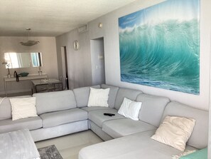 Relax in a comfortable living space with a sofa, coffee table, and a large framed painting.