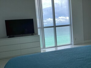 Enjoy ocean views from the large window, relax on the bed with a blue quilted cover, and watch your favorite shows on the flat-screen TV.