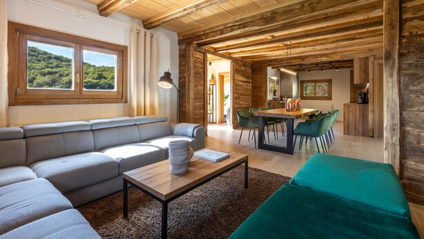 Ein modernes Wohnzimmer mit einer Couch, einem Couchtisch und einem Essbereich mit Stühlen.