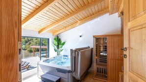 Ein modernes Badezimmer mit Holzboden, einer Glasdusche und einem Holzkabinet.