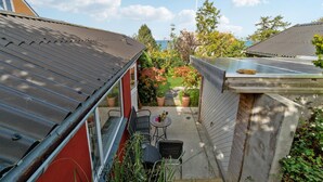 A residential backyard with a patio, potted plants, and a view of the sea. - 2 bedroom amazing apartment in Allinge (Allinge)