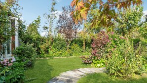 A well-maintained garden with a stone pathway leading to a building entrance. - 2 bedroom amazing apartment in Allinge (Allinge)