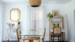 A dining area with a glass table, wooden chairs, a woven pendant light, and a patterned rug. - Vintage inspired 2 bdr home in Pittsburgh near city views (Pittsburgh)