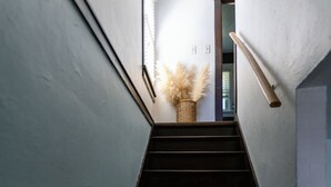 A staircase with a handrail, a basket with pampas grass, and a framed picture on the wall. - Vintage inspired 2 bdr home in Pittsburgh near city views (Pittsburgh)
