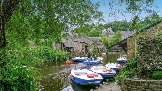 Un canal étroit où plusieurs petits bateaux sont amarrés le long des berges.