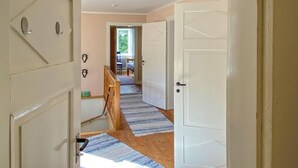 A hallway with a wooden floor, a blue and white striped rug, and a white door. - 6 bedroom gorgeous home in Tranås (Tranås)