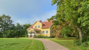 A two-story house with a porch, a paved driveway, and a picnic table in a grassy area. - 6 bedroom gorgeous home in Tranås (Tranås)