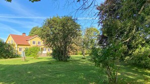 A yellow house with a red roof, surrounded by a well-maintained lawn and trees. - 6 bedroom gorgeous home in Tranås (Tranås)