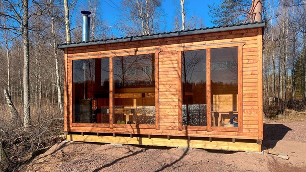 A wooden cabin with large windows and a chimney, surrounded by trees. - 6 bedroom gorgeous home in Tranås (Tranås)