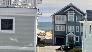 A coastal residential area with houses, a beach, and the ocean in the background. - 🏖️1 min to beach access!🏊‍♂️Heated pool, hot tub, pets, ocean views, arcade! (Nags Head)