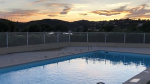 A swimming pool with a metal fence, surrounded by a hilly landscape. - Nouvel Grand Studio Agay vue mar Avec Jardin (Saint-Raphaël)