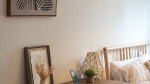A bedroom with a wooden desk, a chair, a bed, and a wall-mounted picture. - Beautiful 1-bed Apartment in Manchester (Manchester)