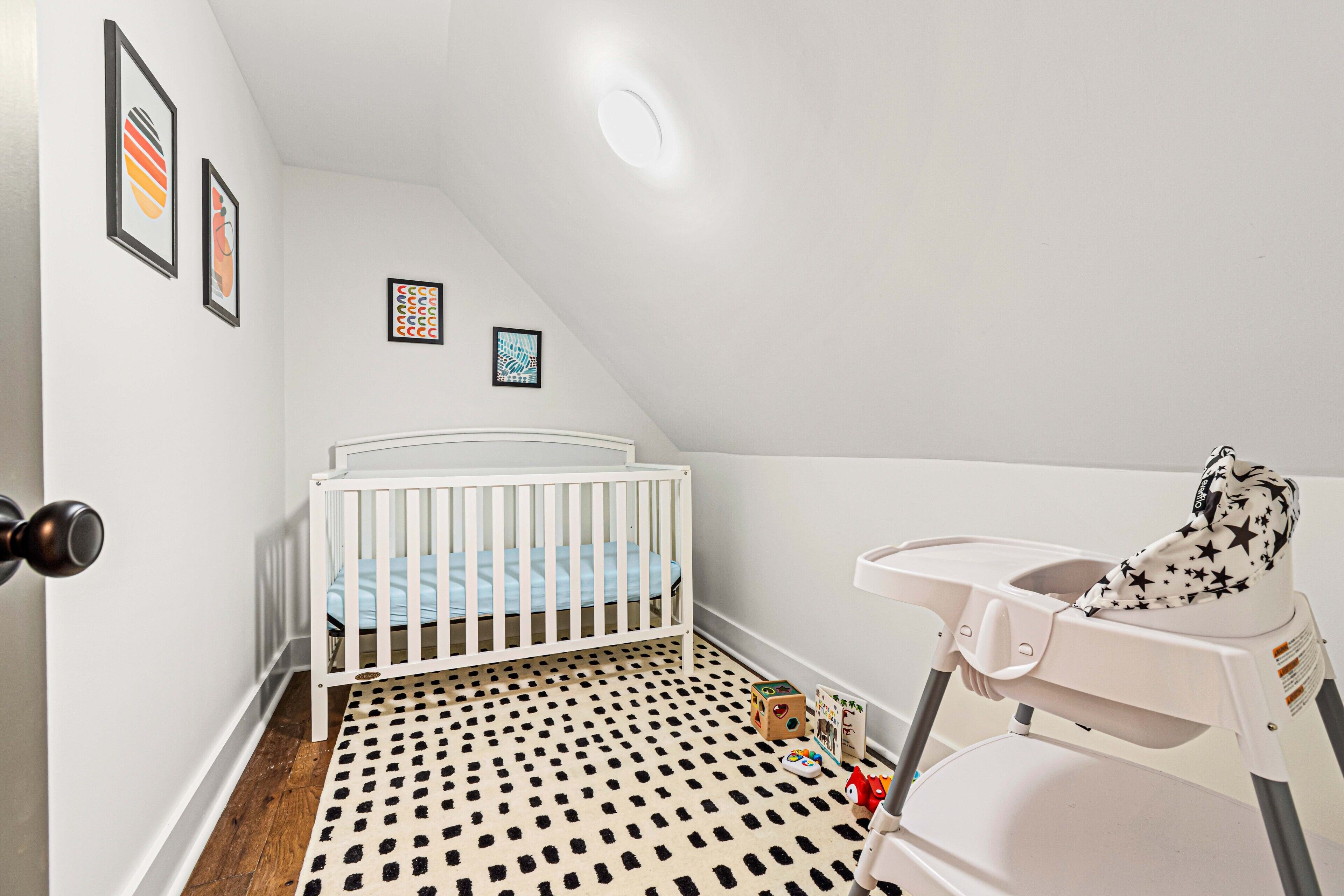 A baby room with a crib, changing table, and a polka dot floor.