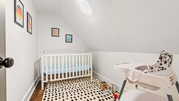 A baby room with a crib, changing table, and a polka dot floor.
