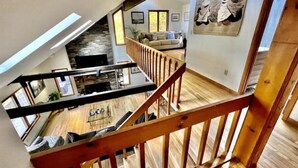 A spacious loft with a high ceiling, wooden beams, and a mezzanine level. - Retreat to Jackson's Ridge and enjoy the Poconos! (East Stroudsburg)