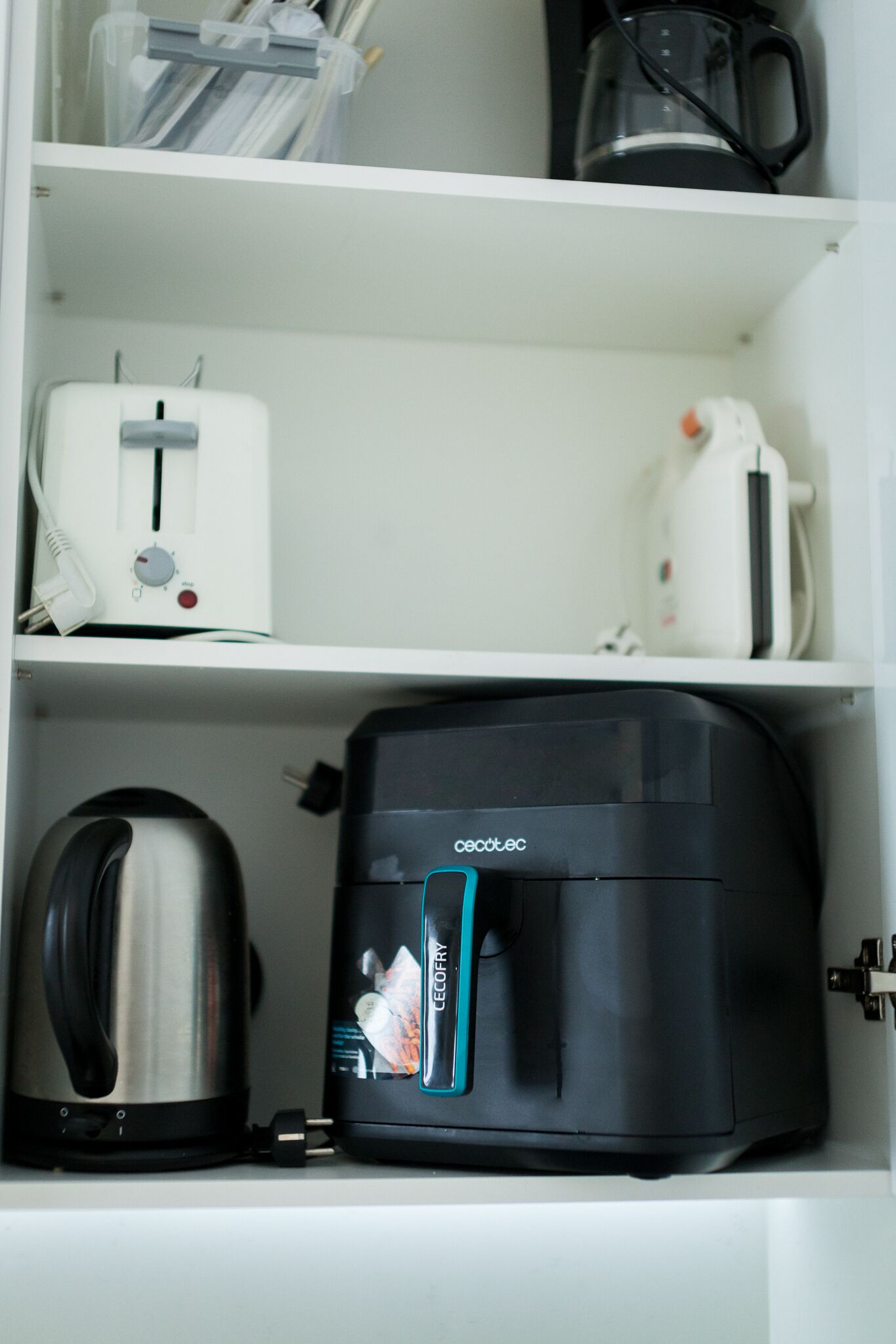 Une cuisine équipée d’un grille-pain, d’une machine à café et d’une bouilloire, le tout posé sur une étagère.